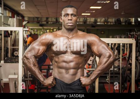 Attraktive Hunky schwarzen männlichen Bodybuilder Bodybuilding Pose im Fitness-Studio zu tun Stockfoto