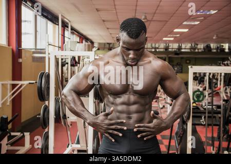 Attraktive Hunky schwarzen männlichen Bodybuilder Bodybuilding Pose im Fitness-Studio zu tun Stockfoto