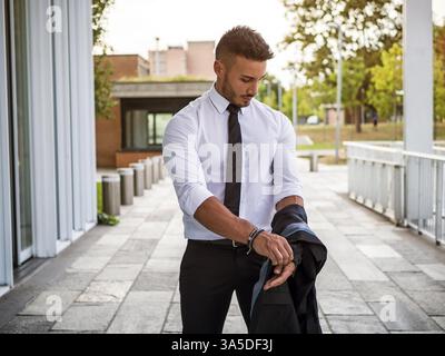 Portrait von stilvollen jungen Mann mit Anzug, stehend in der modernen Stadt Einstellung Stockfoto