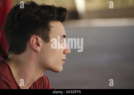 Attraktiven jungen Mannes Seite Ansicht Porträt. Profil gedreht, im freien Stockfoto