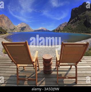 Zwei zusammenklappbare Holzstühle und ein kleiner Nachttisch auf der Promenade. Ein komfortabler Ort, um die Schönheit des Bergsees in Patagonien zu genießen Stockfoto