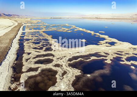 Das blaue Wasser ist von rosa Bergen umgeben. Das malerische Tote Meer ist mit Salzmustern bedeckt. Winter, sonniger Tag. Das Foto wurde von aufgenommen Stockfoto