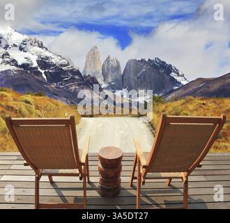 Holzstühle im Park Torres del Paine. Am Horizont ist ein schneebedeckter felsiger Berg zu sehen. Angenehmer Urlaub in Chile Stockfoto
