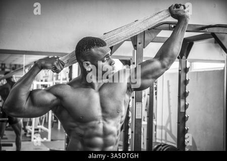 Attraktive Hunky schwarzen männlichen Bodybuilder Bodybuilding Pose im Fitness-Studio zu tun Stockfoto