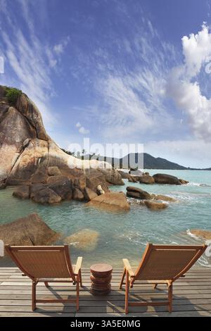 Romantische Ecke am Südufer der Bucht. Zwei bequeme Klappstühle aus Holz und ein kleiner Beistelltisch. Durch das smaragdgrüne Meerwasser sichtbar Stockfoto
