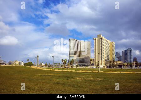 TEL AVIV, ISRAEL - 1. JANUAR 2016: Windiger und heller Wintertag an der Küste. Wolkenkratzer auf dem Damm von Tel Aviv Stockfoto