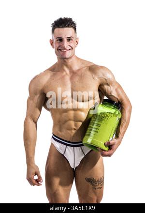 Junger, gutaussehender Bodybuilder, der Proteinbehälter hält und in die Kamera lächelt Stockfoto