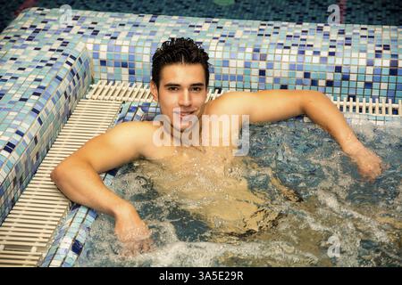 Junger Mann hängen am Schwimmbadrand Entspannung in ruhiger Lage Stockfoto