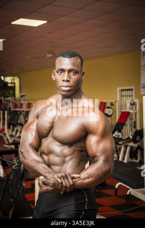 Attraktive Hunky schwarzen männlichen Bodybuilder Bodybuilding Pose im Fitness-Studio zu tun Stockfoto