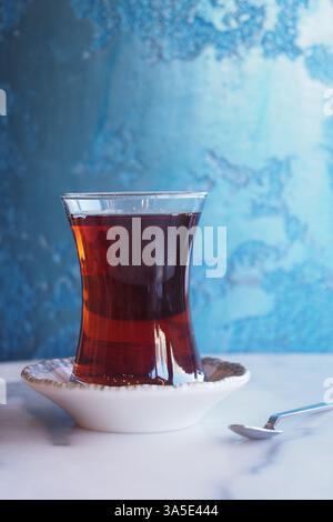Traditioneller türkischer Tee im Glas mit dekorativer Untertasse auf dem Tisch Stockfoto