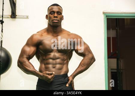 Attraktive Hunky schwarzen männlichen Bodybuilder Bodybuilding Pose im Fitness-Studio zu tun Stockfoto