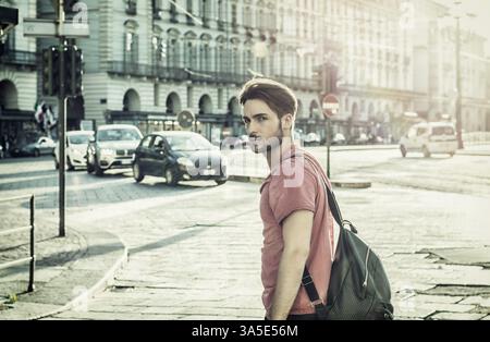 Ein hübscher junger Mann in einer Stadt in Europa, Turin in Italien. In die Kamera schauen, gehen Stockfoto