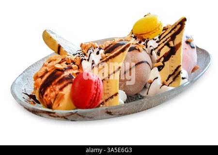 Eiswürfel mit Banane und Chodie Eiswürfel mit Bananen- und Schokoladensauce und Macarons auf weiß isoliert. colate-Sauce und Macarons Stockfoto