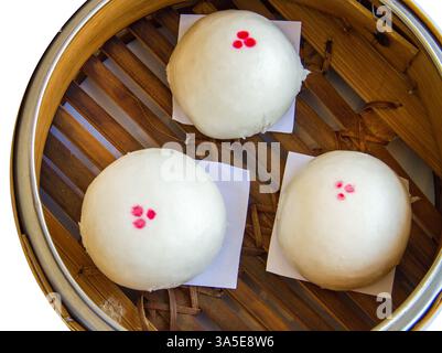 Gestanzt von drei Mini gedämpften Schweinefleisch bao in Korb auf weiß isoliert. Stockfoto