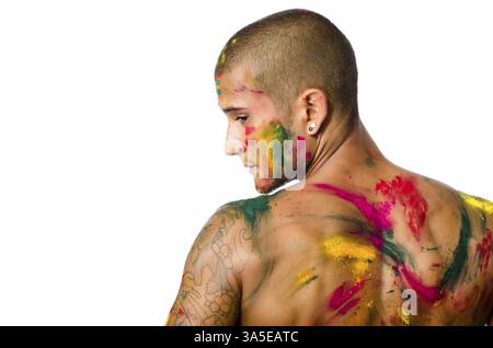 Hübscher junger Mann von hinten mit Haut alle gesehen mit Holi Farben, isoliert auf weißem Hintergrund gemalt Stockfoto