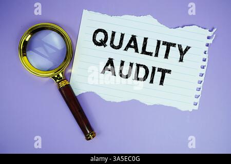 Text der Qualitätsprüfung auf Papier geschrieben mit Vergrößerungsglas flach auf violettem Hintergrund Stockfoto