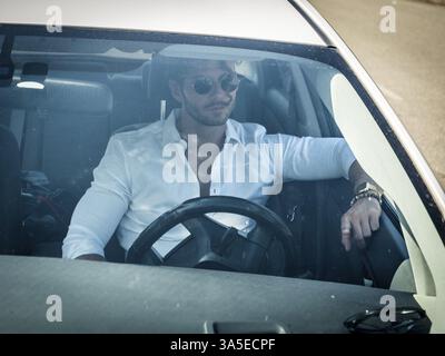 Schöner Mann hinter dem Rad Fahren eines Autos, tragen weiße Hemd, eine Hand am Lenkrad Stockfoto