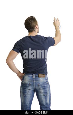 Rücken eines jungen Mannes mit Sprühzeichnung oder Schrift auf leeren, leeren Raum von hinten gesehen Stockfoto