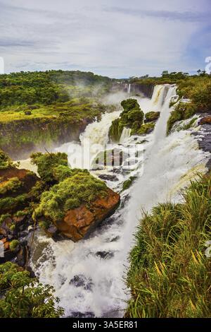 Welt des fallenden Wassers. Die Wasserfälle Iguazu. Malerische basaltische Felsvorsprünge bilden die berühmten Wasserfälle. Das Konzept des aktiven und exotischen Tourismus Stockfoto