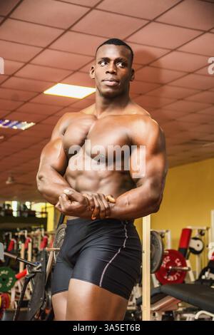 Attraktive Hunky schwarzen männlichen Bodybuilder Bodybuilding Pose im Fitness-Studio zu tun Stockfoto