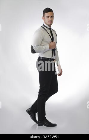 Ganzkörper-Schuss von eleganten und stilvollen junger Mann auf hellem Hintergrund, Profil stehen Stockfoto