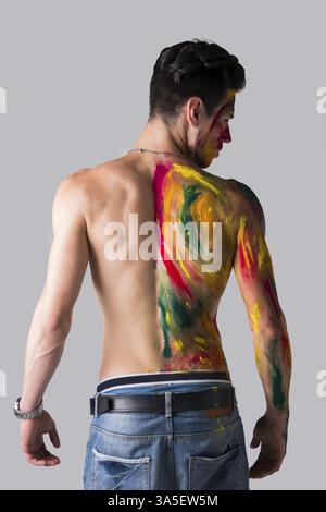 Hübscher junger Mann von hinten mit Haut alle gesehen mit Holi Farben bemalt Stockfoto