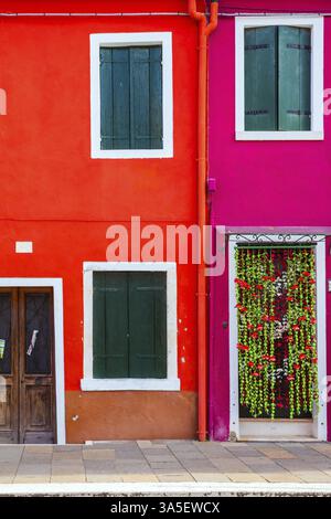 Fassade eines hübschen roten Hauses. Die kleine malerische Insel Burano in der Nähe von Venedig. Das Konzept des Kultur-, Geschichte- und Fototourismus Stockfoto