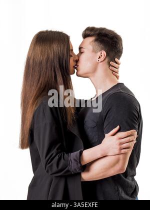Romantisches Paar Küssen in Studio shot, Mann ist muskulös, Frau ist langhaarig und mit schwarzen Shirt Stockfoto
