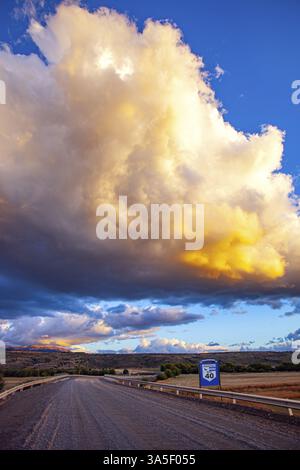 Die berühmte Feldstraße Ruta 40 in Argentinien Patagonien. Die kolossale, malerische Gewitterwolke wird von Blitzeinschlägen durchbohrt und vom Sonnenuntergang erleuchtet. Stockfoto