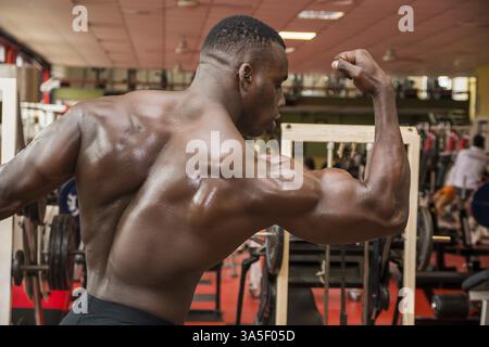 Attraktive Hunky schwarzen männlichen Bodybuilder Bodybuilding Pose im Fitness-Studio zu tun Stockfoto