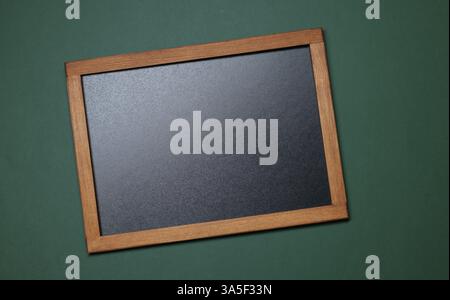 Leere kleine Tafel auf grünem Hintergrund, Draufsicht Stockfoto
