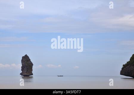 Flacher Sandstrand. Die malerische Bucht im Golf von Thailand ist von Inseln umgeben - Felsen verschiedener Formen. Nebeliger Morgen nach einem schweren Sturm Stockfoto