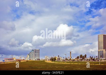 TEL AVIV, ISRAEL - 1. JANUAR 2016: Starke Winde und helle Sonne - perfektes Wetter für einen Winterspaziergang. Wolkenkratzer an der Küste von Tel Aviv Stockfoto