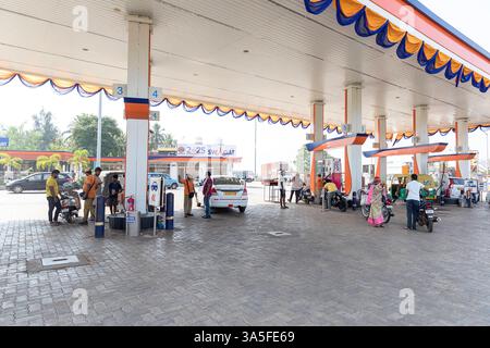 Menschen stehen und warten mit ihren Motorrädern in der Tankstelle in orissa in indien Stockfoto