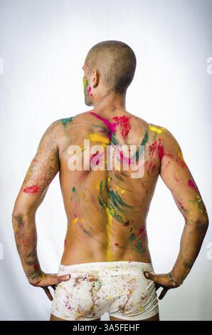 Hübscher junger Mann von hinten mit Haut alle gesehen mit Holi Farben bemalt Stockfoto