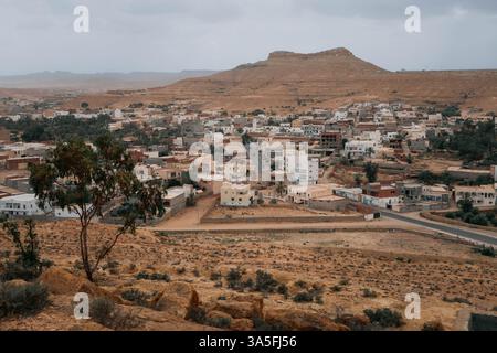 Ein Panoramablick auf Tataouine, Tunesien, mit traditionellen Lehmziegelhäusern, zerklüfteten Hügeln und trockener Wüstenlandschaft Stockfoto