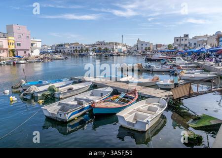 Ein lebendiger Yachthafen in Bizerte, Tunesien, mit farbenfrohen Booten an Holzpiers, umgeben von bezaubernder Architektur und ruhigem Wasser. Stockfoto