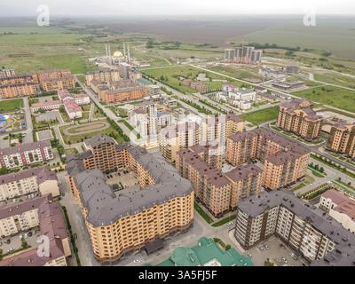 Luftpanorama von Magas, Inguschetien, Russland, mit Panoramablick auf die Stadt mit Wohngebäuden, einer großen Moschee und einer urbanen Stadtlandschaft. Stockfoto