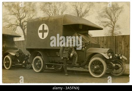 Ursprünglicher britischer Krankenwagenfahrer aus dem 1. Weltkrieg, Army Service Corps (ASC)-Kappenabzeichen, ein Schlüsselband auf seiner Schulter, neben der Kabine seines Krankenwagens, einer aus einer Flotte von Krankenwagen, rotes Kreuz auf der Seite. Der junge Mann hat vielleicht an einer der Motorenprüfschulen in London oder Glasgow ausgebildet. Soldaten des Ersten Weltkriegs. Britische Postkarte, 1914-1918. Stockfoto