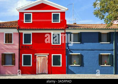 Die kleine malerische Insel Burano in der Nähe von Venedig. Fassade eines hübschen rot-blauen Hauses. Das Konzept der kulturellen, historischen und Fototouri Stockfoto