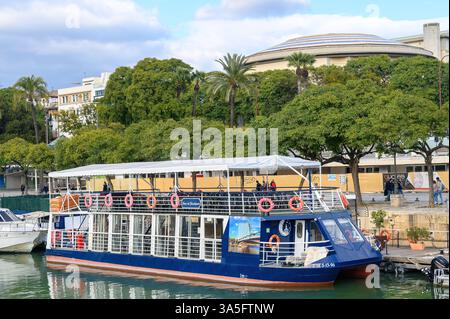 Ein Ausflugsboot, das am Ufer des Guadalquivir-Flusses vor Anker liegt. Stockfoto