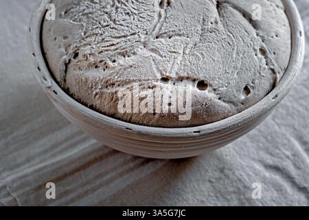 Nahaufnahme eines aufsteigenden Sauerteigs in einem Rattankorb Stockfoto