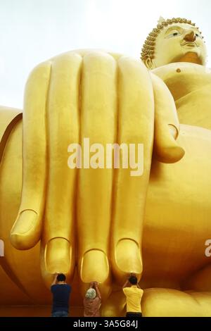 Menschen, die die Finger des Großen Buddha-Bildes für den Segen berühren, Wat Muang Tempel, Provinz Ang Thong, Thailand Stockfoto