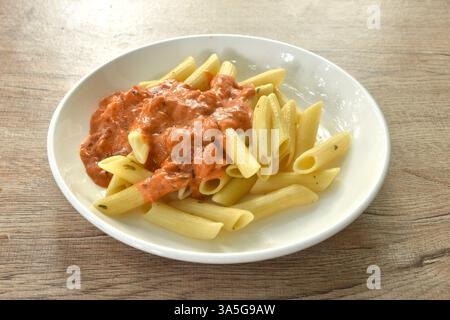 Penne Pasta backen, Lachsscheiben in süß-saurer Sauce auf dem Teller Stockfoto