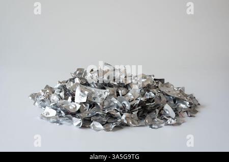 Ein großer Stapel leerer Aluminium-Blisterpackungen für Arzneimittel auf einer weißen Oberfläche, die pharmazeutische Abfälle, Umweltprobleme und die Bedeutung darstellen Stockfoto