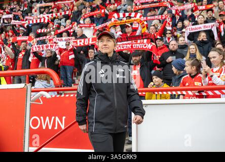 Berlin, Deutschland. März 2025. Fußball, Frauen: Bundesliga 2, 1. FC Union Berlin - SC Sand, 19. Spieltag, an der Alten Försterei. Union Coach Ailien Poese kommt auf das Spielfeld, während die Union-Fans die Vereinshymne singen. Quelle: Matthias Koch/dpa/ZB/dpa/Alamy Live News Stockfoto