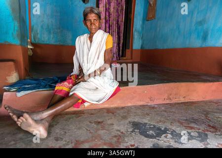 Frau mit bunten traditionellen indischen Kleidern Sari vor einem Eingang zu einem Haus, Gunupur, orissa, indien Stockfoto