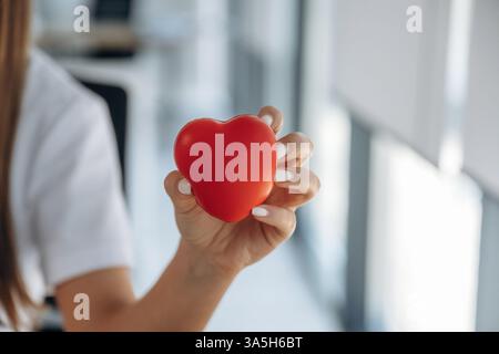 Nahaufnahme, mit dem kleinen roten Herzen. Professionelle Ärztin in der Klinik drinnen. Stockfoto