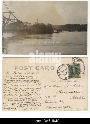 Dieses Postkartenfoto, das 1908 vom Levee Park in St. Peter aufgenommen wurde, zeigt den überfluteten Minnesota River, wobei die Broadway Bridge und das Eisenbahndepot im Le Sueur County auf der anderen Seite des Flusses sichtbar sind. Stockfoto