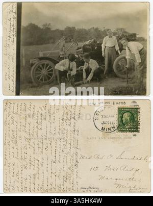 Auf diesem Bild aus dem Jahr 1911 wird Harry Hedberg gesehen, wie er einen Platten Reifen an einem Auto aus dem frühen 20. Jahrhundert repariert. Er ist mit drei anderen Männern abgebildet, die eine Pumpe benutzen, um den Reifen zu reparieren. Stockfoto